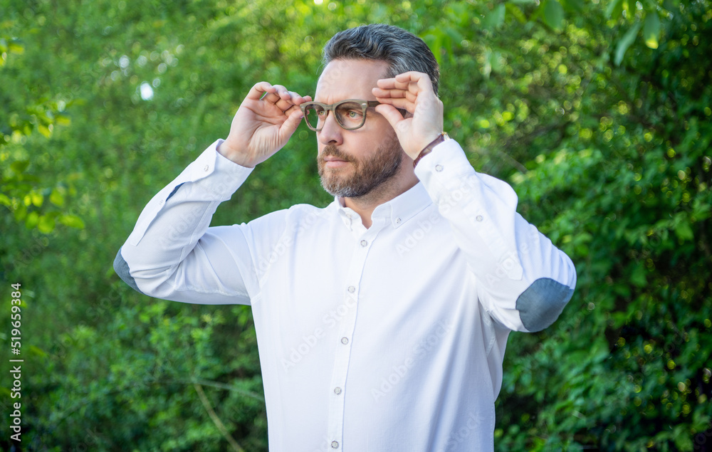Handsome businessman looking into distance in eyeglasses natural background, eyesight Handsome businessman looking into distance in eyeglasses natural background, eyesight