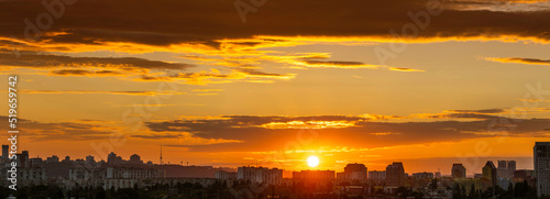 Amazing panoramic view of the big city evening silhouette against the backdrop of incredibly, awesome bright, multi colored clouds at sunset. Kyiv in last days in july 2022. Ukraine.