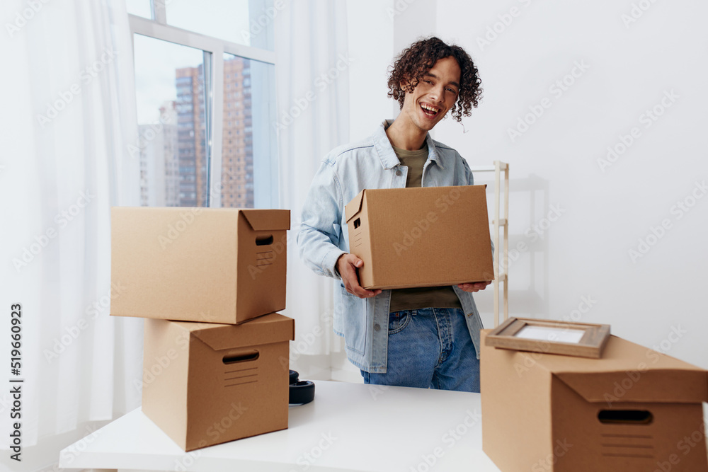 handsome guy unpacking with box in hand sorting things out handsome guy unpacking with box in hand sorting things out