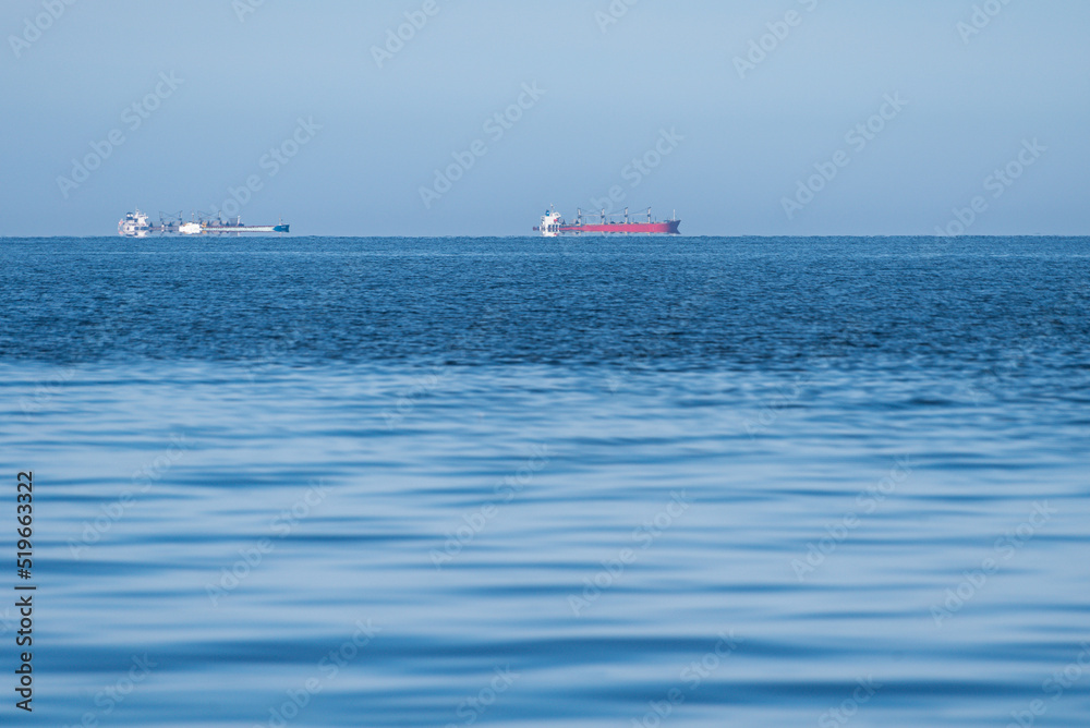 Cargo ships at sea on a sunny summer day.