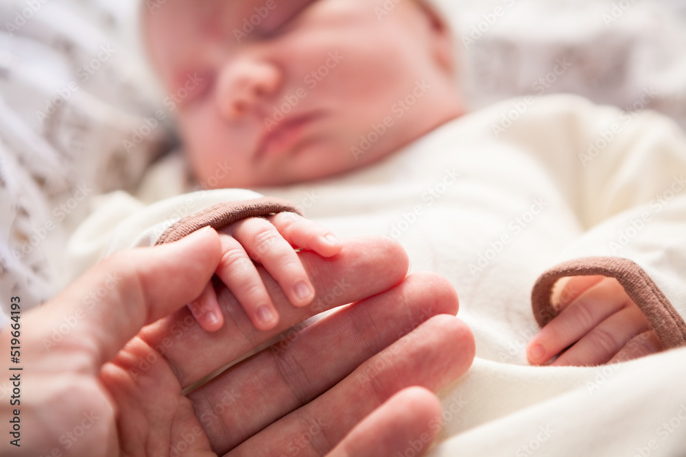 Hands of dad and mom with fingers of a newborn baby Hands of dad and mom with fingers of a newborn baby