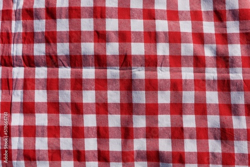Red checkered picnic tablecloth as background, top view