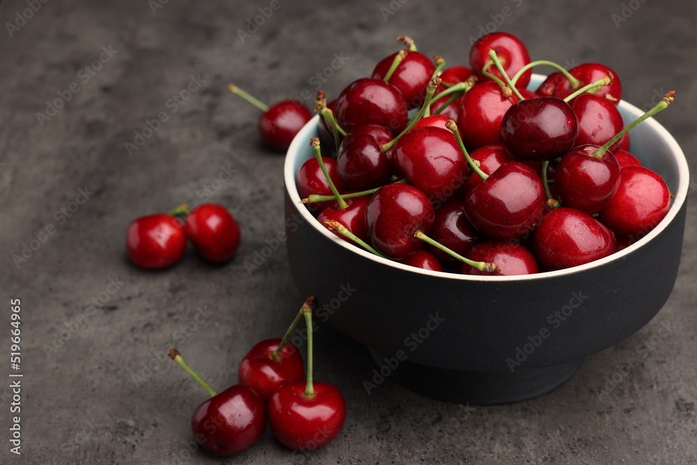 Bowl with ripe sweet cherries on dark grey table, space for text Bowl with ripe sweet cherries on dark grey table, space for text