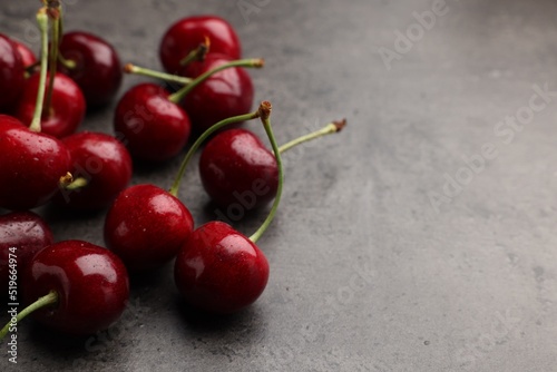 Many sweet cherries on grey table, space for text