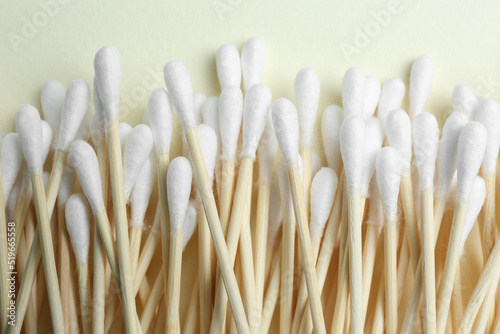 Heap of cotton buds on beige background, top view