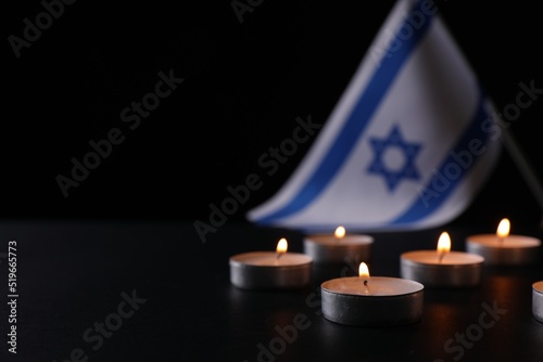 Burning candles on black table, space for text. Holocaust memory day photo