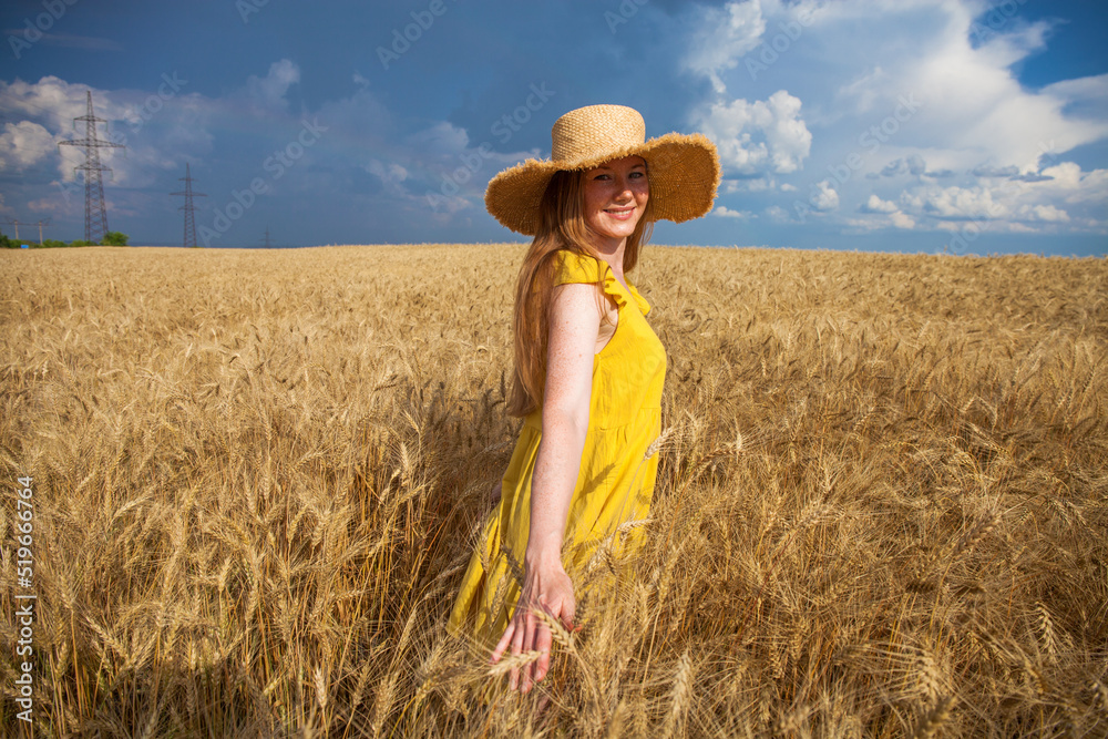 Obraz premium Happy red-haired woman posing in a wheat field