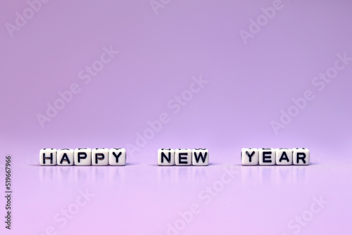 New Year's card. Design of Christmas decorations, happy new year inscription on white cubes, purple background Happy New Year. Realistic