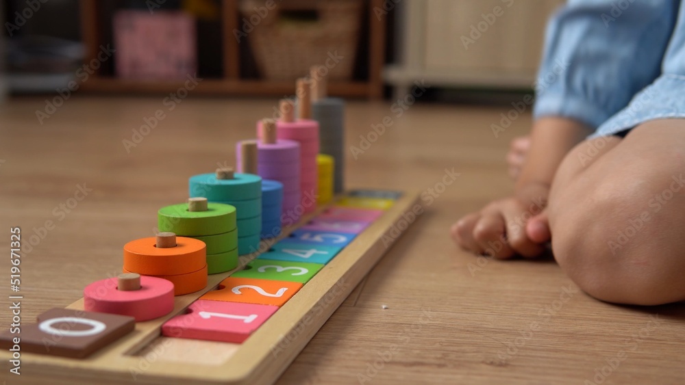 Happy Little Preschool Toothless Girl Playing With Colored Wooden Toy. Kids Learn To Count By Playing Teaches Numbers At Home. Child Listening To Music In Big White Headphones. Childhood, Education Happy Little Preschool Toothless Girl Playing With Colored Wooden Toy. Kids Learn To Count By Playing Teaches Numbers At Home. Child Listening To Music In Big White Headphones. Childhood, Education