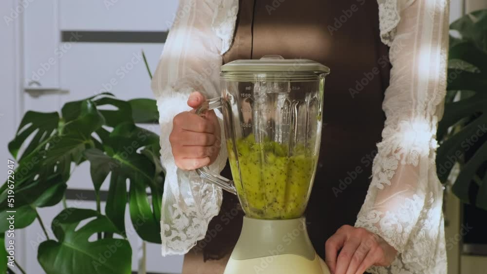 Making fresh smoothie with kiwi in blender closeup. Fruit smoothie