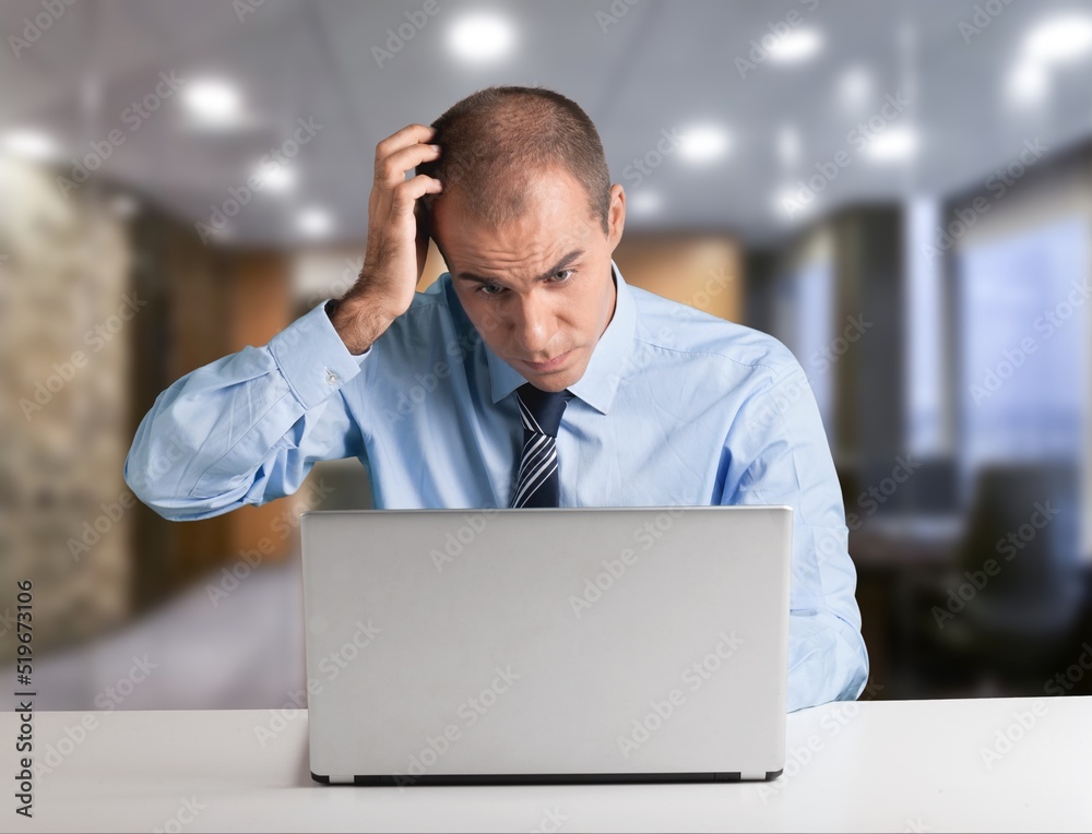 Young businessman using computer in office, thinking. Happy middle aged man, entrepreneur working online. Young businessman using computer in office, thinking. Happy middle aged man, entrepreneur working online.