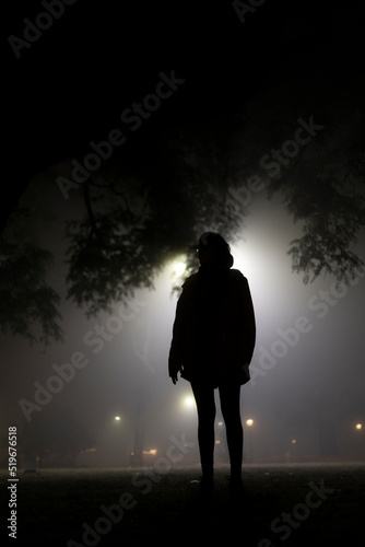 Silueta de mujer en la noche con neblina