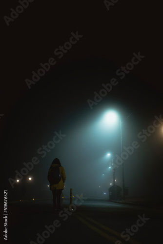 Mujer caminando sola en la noche con niebla photo
