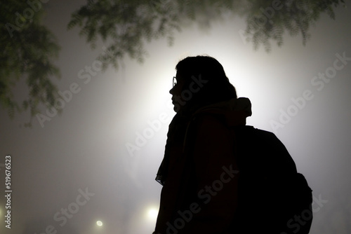 Silueta de mujer en la noche con neblina