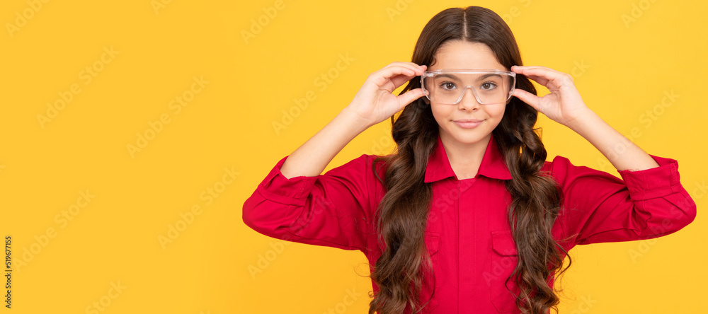 smiling teenager girl wearing protective glasses, eye protection. Child builder with protective glasses horizontal poster design. Banner header, copy space.