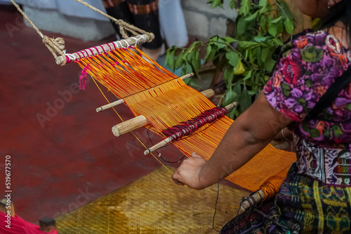 Closeup view of a Guatemalan Indigenous woman working in a traditional and typical handmade textile photo
