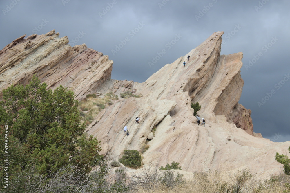 Hikers on the surface of tilted white sandstone rocks, Vasquez Rocks Natural Area and Nature Center