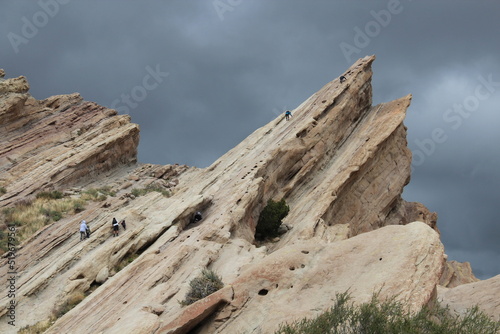 Appearing small hikers on the surface of tilted white sandstone rocks, Vasquez Rocks Natural Area and Nature Center