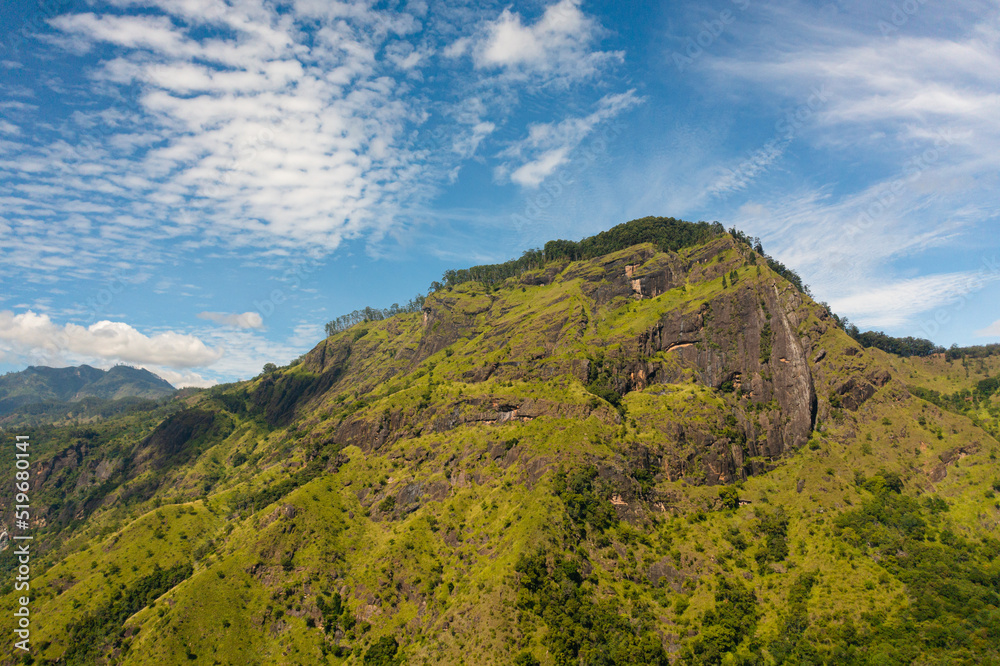 Top view of Mountain with tropical vegetation and trees against a background of blue sky and clouds. Mountain landscape in Sri Lanka.