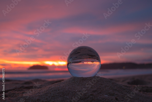 amazing view of the sea and sky in beautiful sunset are unconventional and beautiful inside crystal ball. .A image for a unique and creative travel.