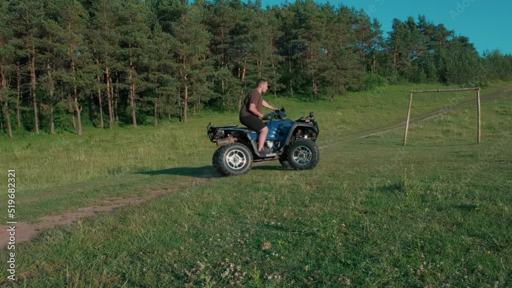A guy on a quad motorcycle drifts on wheels.A teenager rides an ATV in a field.Four-wheel ATV transport and extreme sport. A guy on a quad motorcycle drifts on wheels.A teenager rides an ATV in a field.Four-wheel ATV transport and extreme sport.