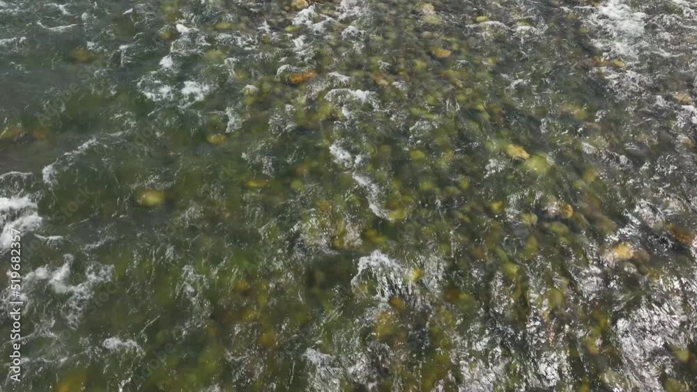 Rising aerial shot over a shallow river with rapids. Rising aerial shot over a shallow river with rapids.