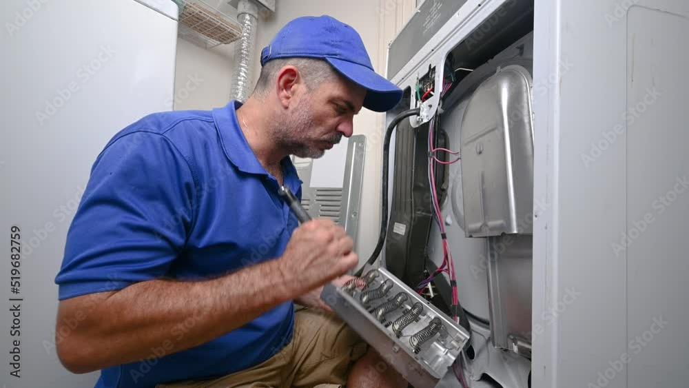 Appliance technician inspecting a heating element Appliance technician inspecting a heating element