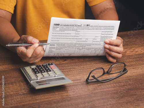 Tax day concept. Businessman using a tax form to complete individual income tax payment form photo