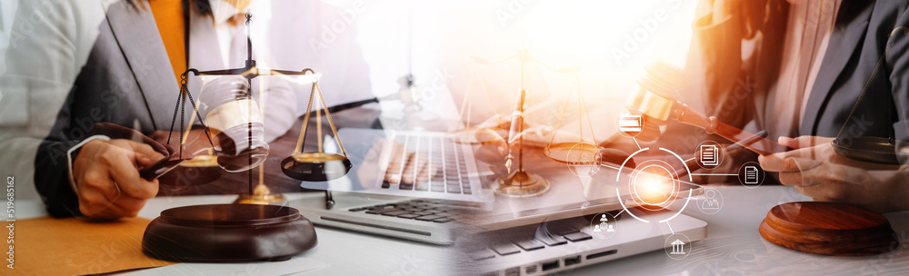 Fototapeta premium Justice and law concept.Male judge in a courtroom with the gavel, working with, computer and docking keyboard, eyeglasses, on table in morning light