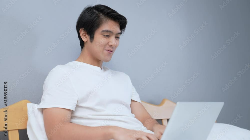 Holiday concept of 4k Resolution. Asian man using computer for video call in bedroom. Holiday concept of 4k Resolution. Asian man using computer for video call in bedroom.