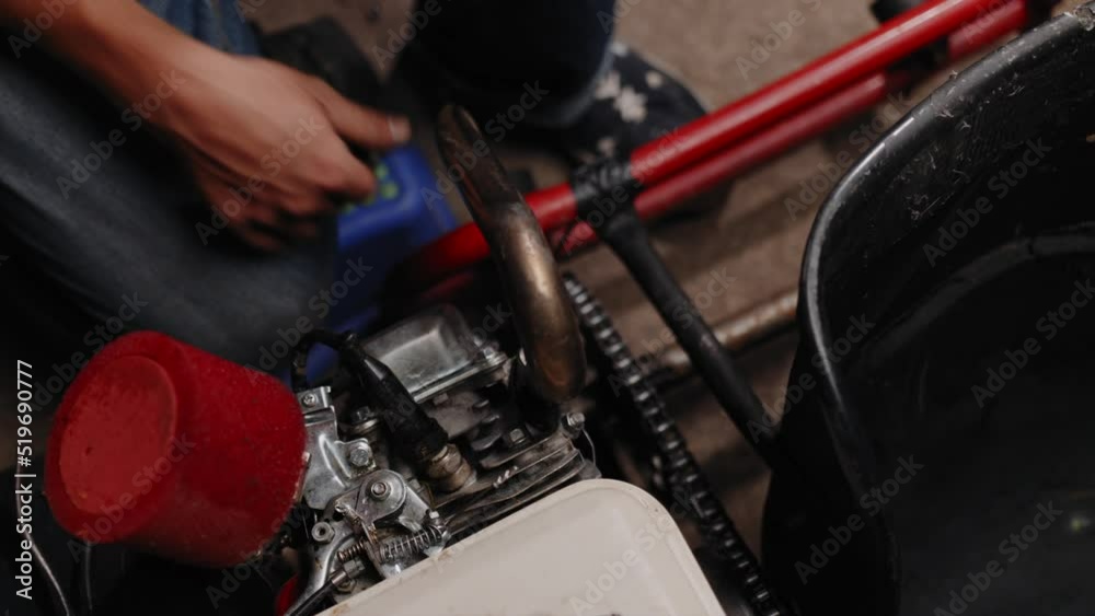 Close up shot of mechanic fitting the chain on his DIY go-kart. Close up shot of mechanic fitting the chain on his DIY go-kart.