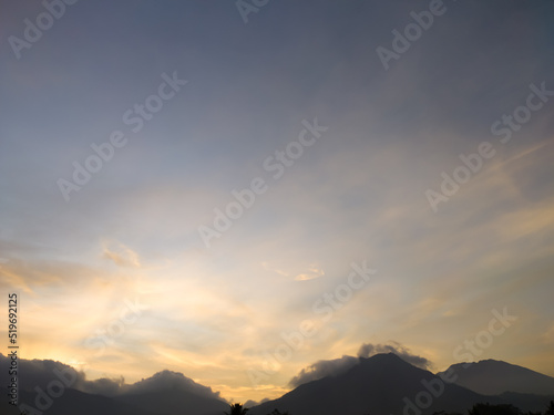 The view of the sky and the peaks of the mountains below as the sun begins to rise.