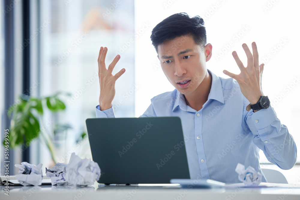 Frustrated, annoyed and irritated business man looking angry while working on his laptop. Young male worker feeling upset or struggling with an internet crash while at his desk in the office Frustrated, annoyed and irritated business man looking angry while working on his laptop. Young male worker feeling upset or struggling with an internet crash while at his desk in the office