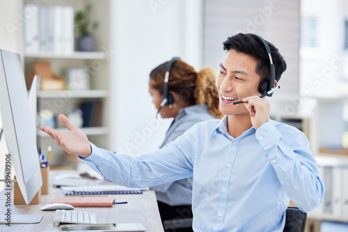 Happy, confident and helpful call centre agent talking on a headset while working on computer in an office. Salesman or consultant operating a help desk for customer care and service support