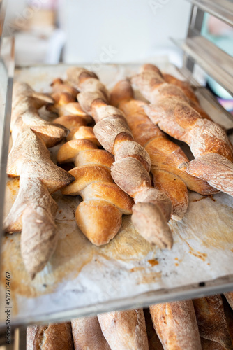 Finished French bread in the bakery on the racks. Baguettes, rustic bread. Vertical photo.