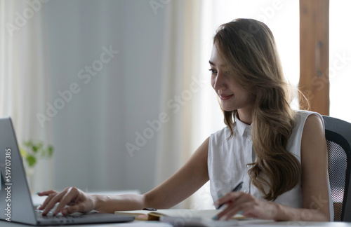 Portrait of Asian young female working on laptop at office