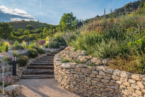 Rustic wooden stairs and stone wall in the garden.