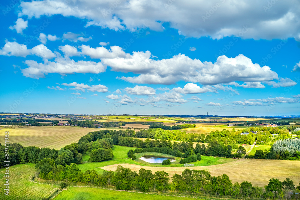 Farming, agricultural remote view of lush fields, cultivated outdoors on a sunny day. Vibrant and bright pastures growing on farmland with blue sky background over a vast and open meadow