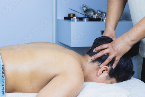 Relaxed young brunette latina woman receiving a decontracting oil massage in a spa salon