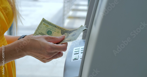 Woman counting us dollars near ATM machine 