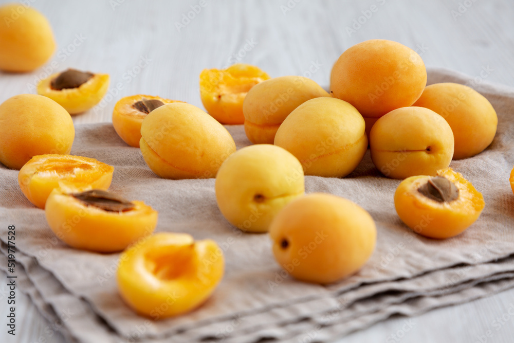 Raw White Apricot Angelcots on a white wooden surface, low angle view.