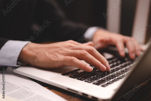 closeup business hand working to typing computer laptop keyboard in modern office or home workplace desk table, businessman using notebook for online technology communication job by using cyberspace