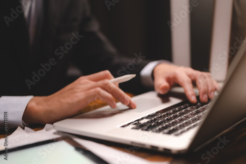 closeup business hand working to typing computer laptop keyboard in modern office or home workplace desk table, businessman using notebook for online technology communication job by using cyberspace
