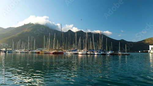 Serene scene of sailboats moored in marina, sunny weather beautiful mountains photo