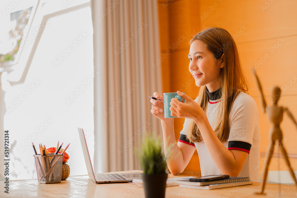Beautiful ambitious Asian female employee working from home. girl using laptop smile like a dream Students feel inspired to write an essay. Beautiful ambitious Asian female employee working from home. girl using laptop smile like a dream Students feel inspired to write an essay.