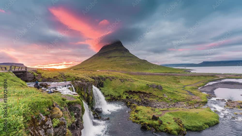 Sunset over Kirkjufell mountain with cap cloud blowing through and Kirkjufellsfoss waterfall in summer at Iceland Sunset over Kirkjufell mountain with cap cloud blowing through and Kirkjufellsfoss waterfall in summer at Iceland
