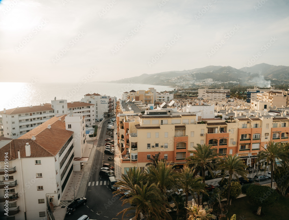 Tropical seaside town in Spain close to the ocean & coast with colourful buildings & mountains. 