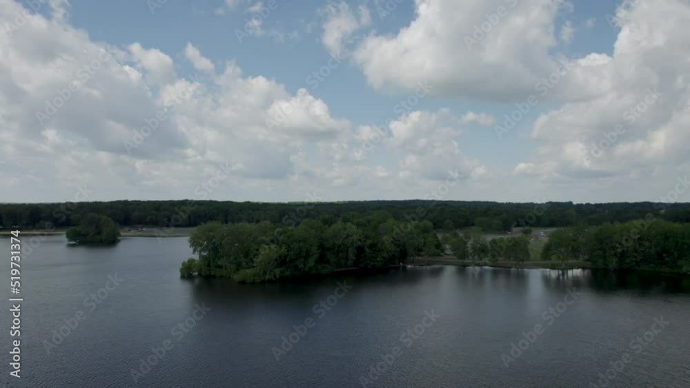 Left side tracking with drone over lake on sunny day with beautiful clouds Left side tracking with drone over lake on sunny day with beautiful clouds