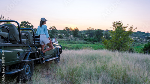Asian women on a safari game drive in South Africa Kruger national park. women on safari. Tourist in a jeep looking sunset on safari photo