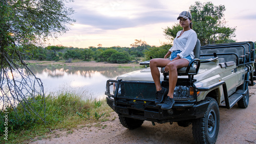 Asian women on a safari game drive in South Africa Kruger national park. women on safari. Tourist in a jeep looking sunset on safari